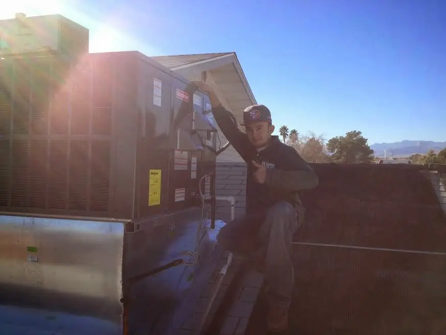 HVAC technician performing AC Tune-Up on a rooftop unit in Archer Lodge